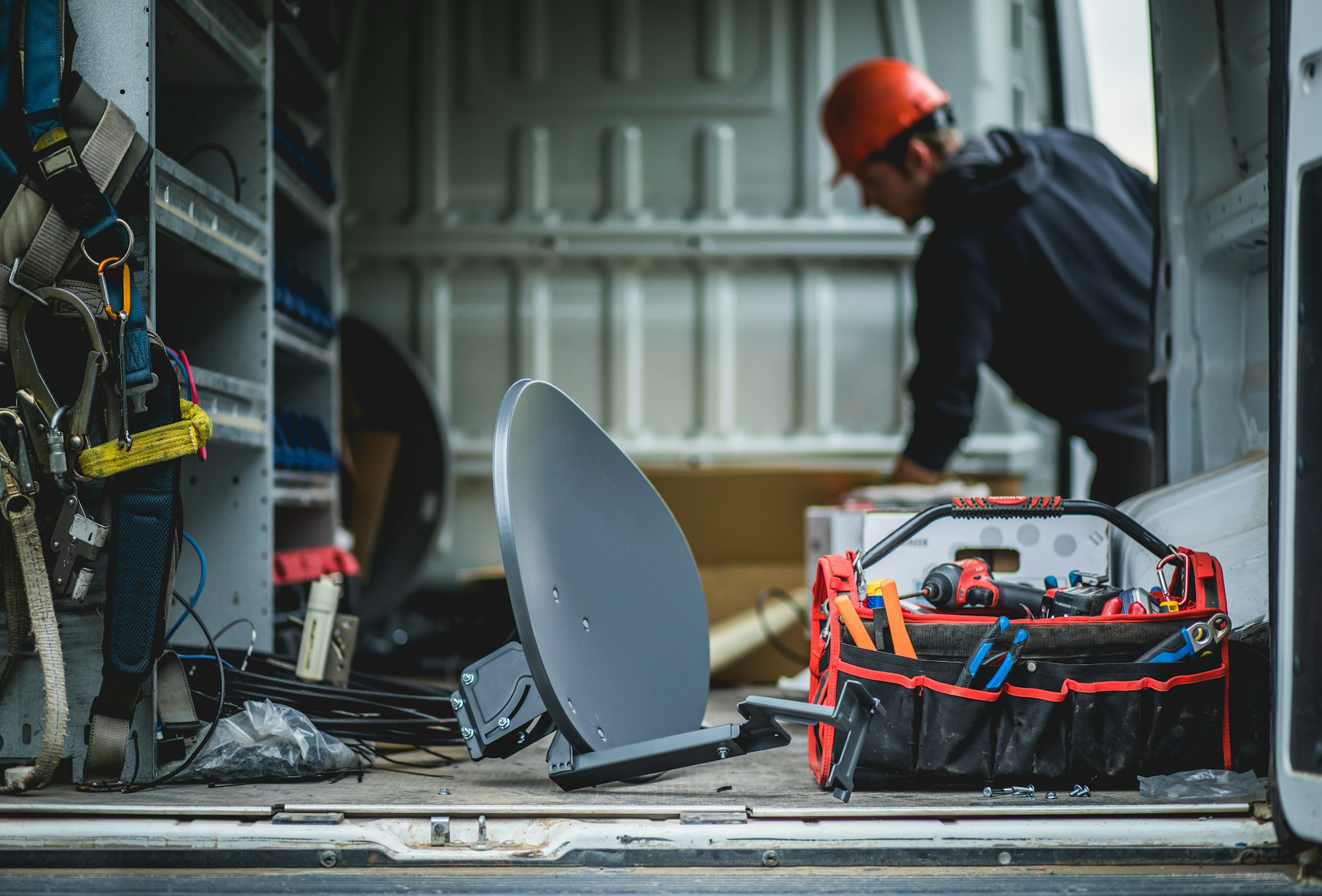 Young technician and van with satellite antenna.